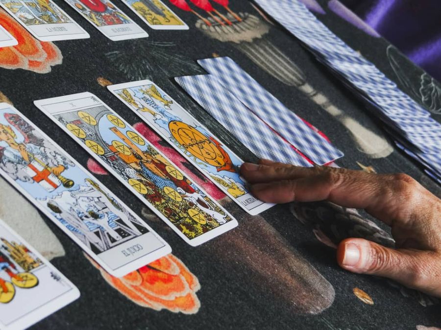 Main posée sur un tirage de cartes de tarot